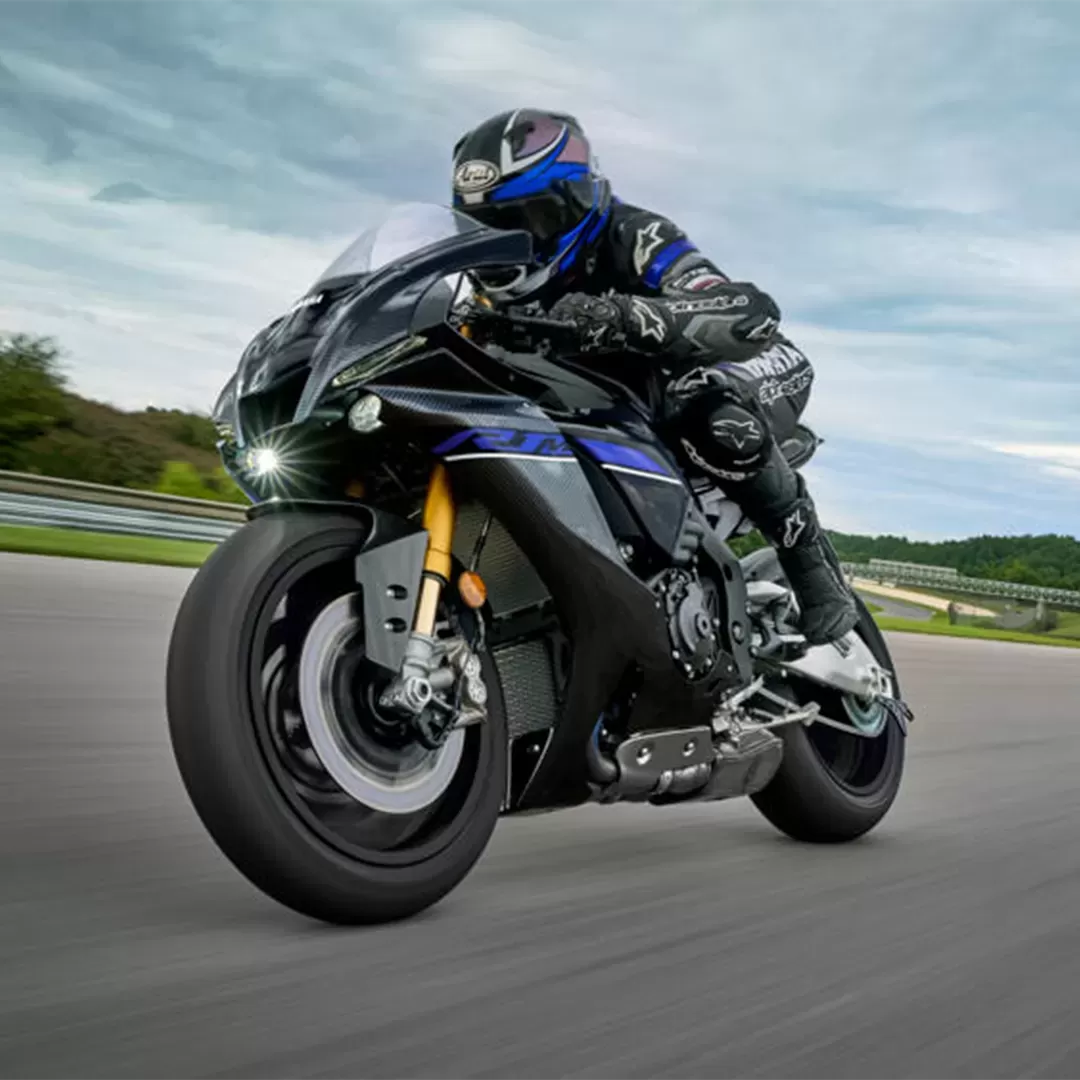 Sport motorcycle on new tyres, low lean angles, dry road.